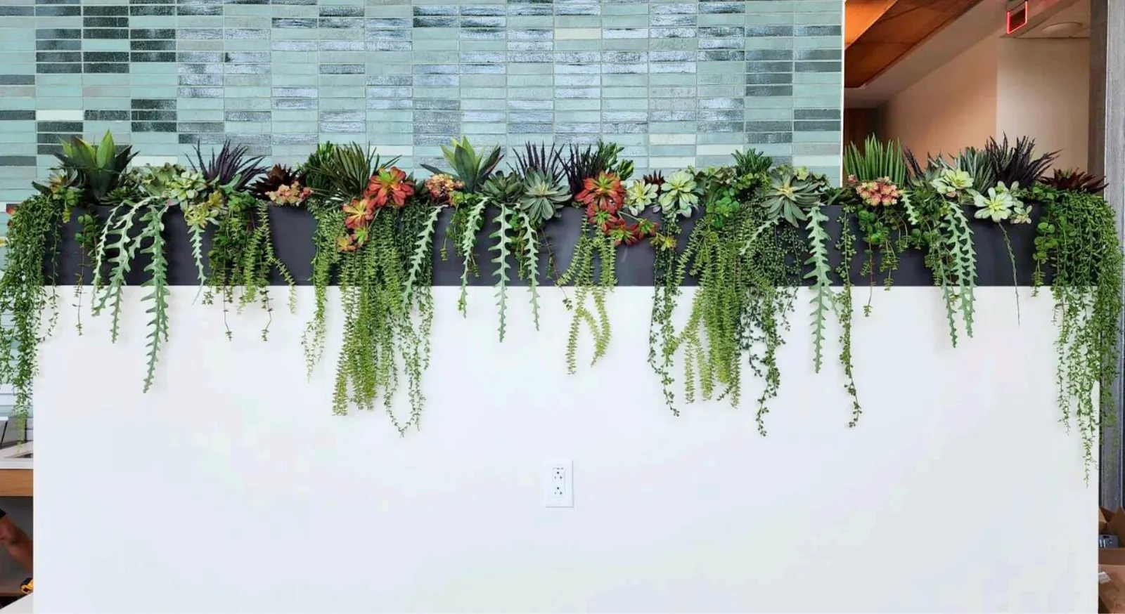 Lifelike silk greenery cascading from a planter wall